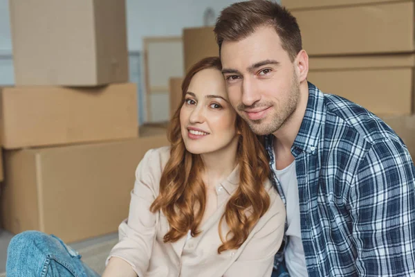 Portrait of young couple at new apartment with cardboard boxes, relocation concept — Stock Photo