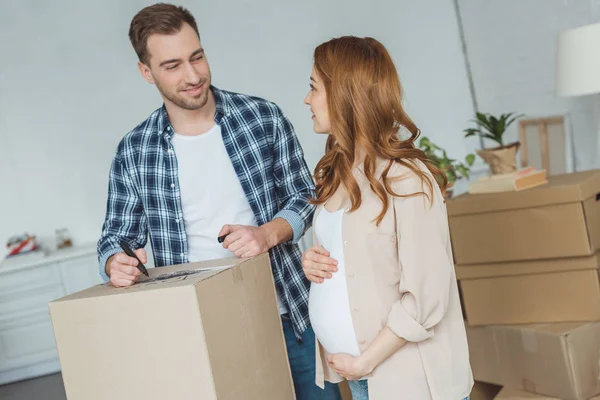 Pregnant woman and husband at new apartment, relocation concept — Stock Photo