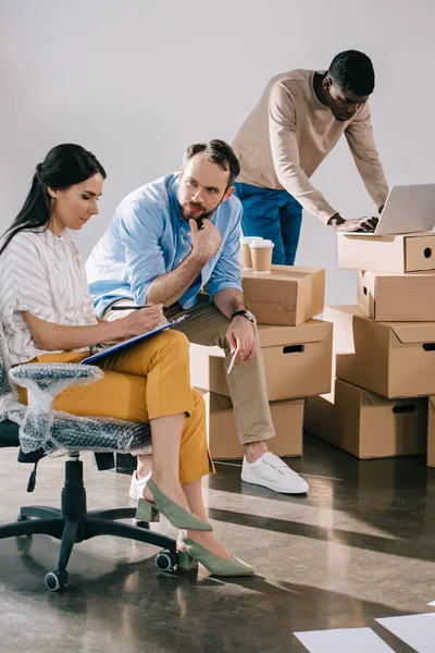 Gens d'affaires multiraciaux travaillant ensemble lors de la réinstallation dans un nouveau bureau — Photo de stock