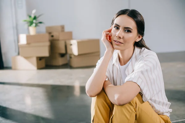 Beautiful young woman looking at camera while sitting in new office during relocation — Stock Photo