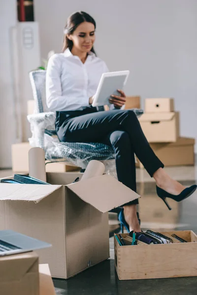 Jeune femme d'affaires souriante utilisant une tablette numérique dans un nouveau bureau — Photo de stock