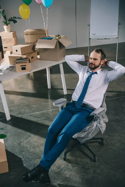 Високий кут зору бізнесмена, що сидить з руками за голову в новому офісі — стокове фото