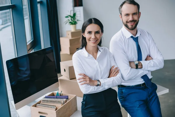 Hommes d'affaires confiants avec les bras croisés souriant à la caméra sur le nouveau lieu de travail — Photo de stock