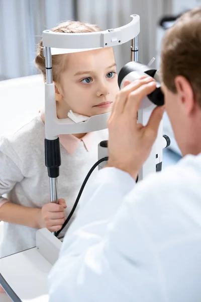 Cropped image of ophthalmologist examining vision of child with slit lamp in clinic — Stock Photo