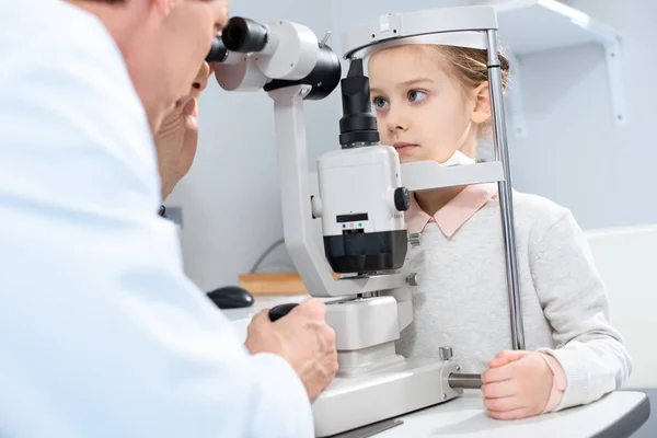 Augenarzt untersucht präadoleszentes Kindersehen mit Spaltlampe in Klinik — Stockfoto