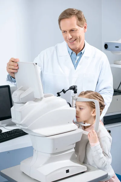 Ophthalmologist examining vision of pre-adolescent child in clinic — Stock Photo