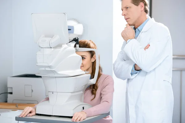 Офтальмолог вивчає зір пацієнта в клініці — стокове фото