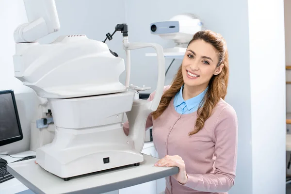 Felice giovane donna guardando la fotocamera in oculista sala di consultazione — Foto stock