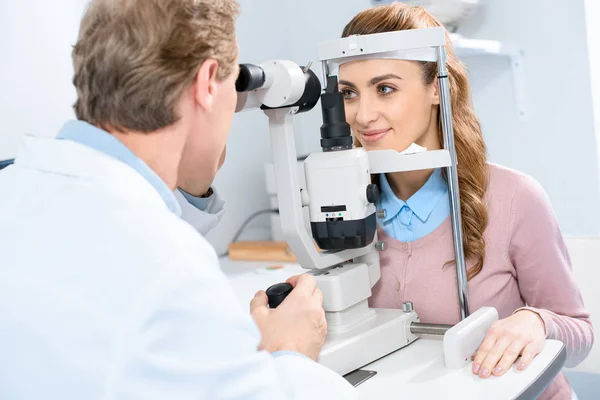 Augenarzt untersucht weibliches Sehvermögen mit Spaltlampe in Klinik — Stockfoto