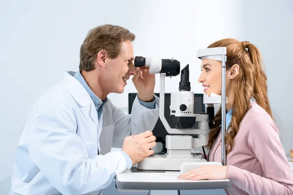 Vista laterale dell'oftalmologo che esamina la vista del paziente con lampada a fessura in clinica — Foto stock