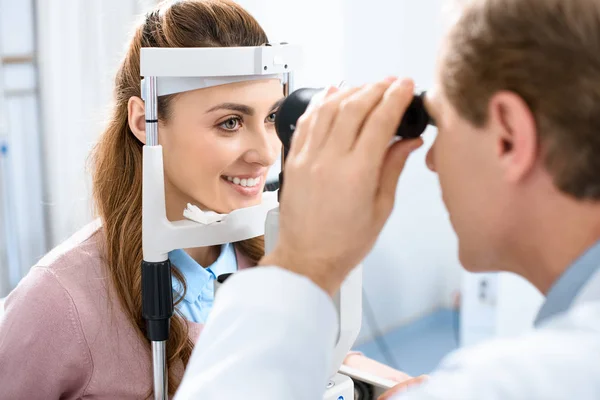 Ophthalmologist examining patient vision with slit lamp in clinic — Stock Photo