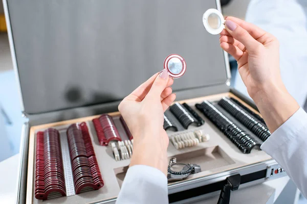 Cropped view of ophthalmologist holding lenses for trial frame — Stock Photo