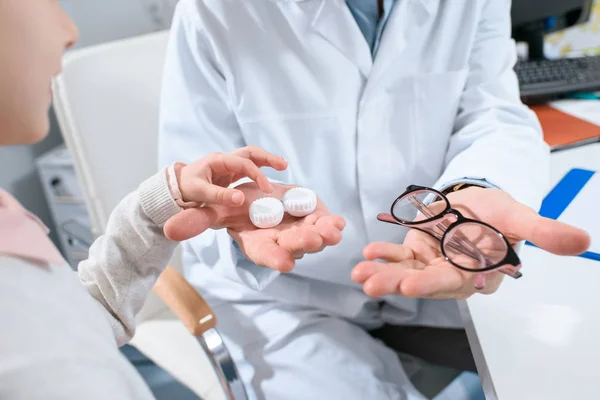 Vue recadrée du choix de l'enfant en lunettes ou lentilles oculaires en optique — Photo de stock