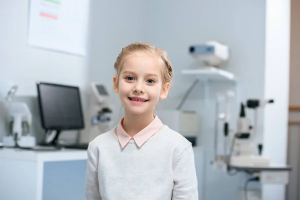 Niño sonriente en clínica óptica - foto de stock