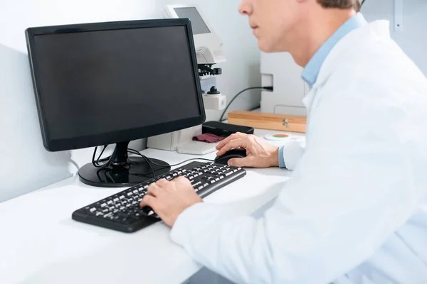 Ausgeschnittene Ansicht eines männlichen Optikers, der in der Klinik mit dem Computer arbeitet — Stockfoto