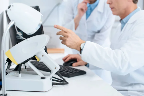 Cropped view of opticians working with computer in clinic — Stock Photo
