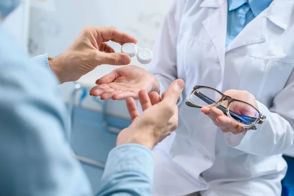 Vue recadrée de l'homme choisissant des lunettes et / ou des lentilles en optique — Photo de stock