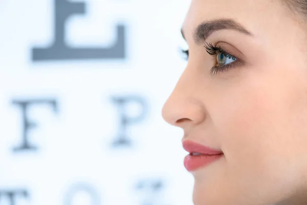 Profilo di bella donna con test dell'occhio in ottica — Foto stock