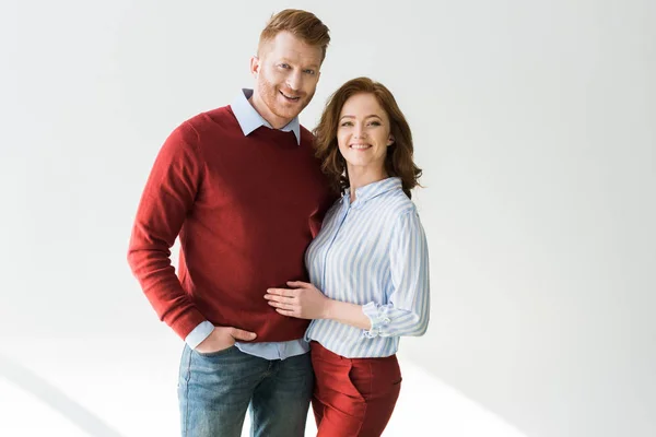 Cheerful red haired couple standing together and smiling at camera on grey — Stock Photo