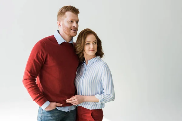 Porträt eines schönen rothaarigen Paares, das zusammensteht und isoliert auf grau wegschaut — Stockfoto