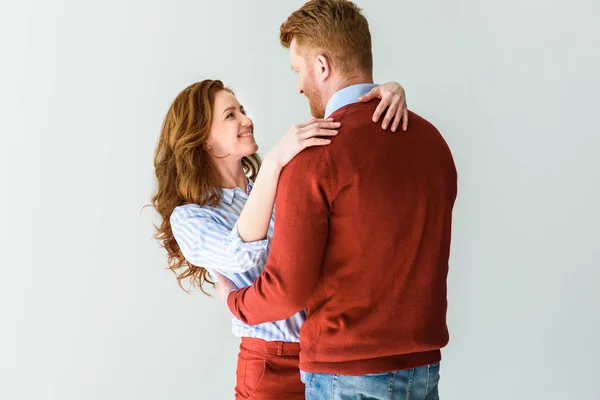 Belo casal feliz abraçando e sorrindo uns aos outros isolado em cinza — Fotografia de Stock