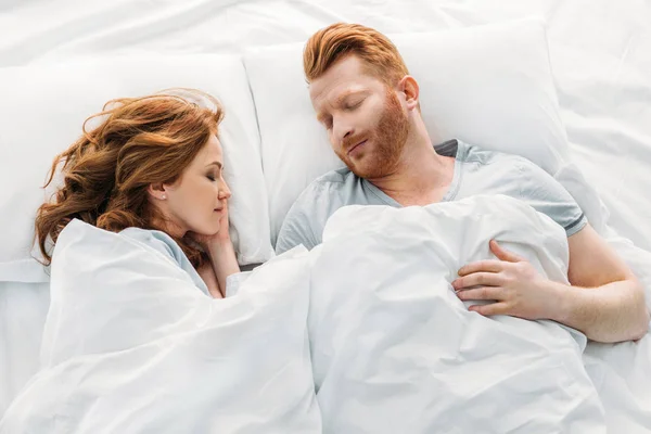 Draufsicht des schönen rothaarigen Paares, das zusammen im Bett schläft — Stockfoto