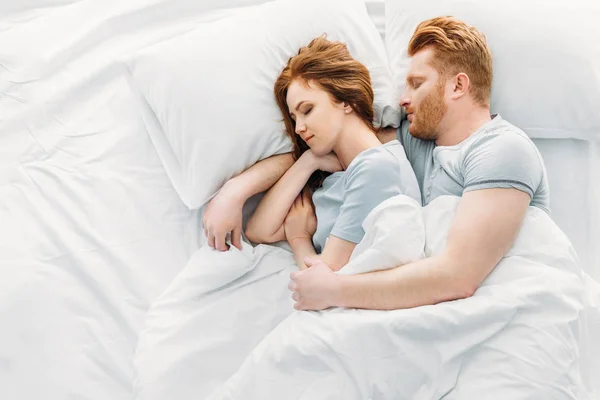 Вид сверху красивой рыжеволосой пары, спящей вместе в постели — стоковое фото