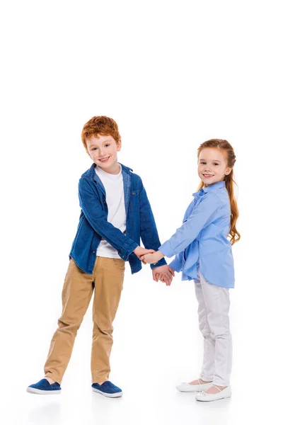 Beaux rousses frères et sœurs tenant la main et souriant à la caméra isolé sur blanc — Photo de stock