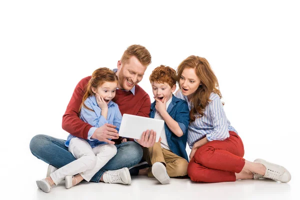 Surprised family with two kids using digital tablet together isolated on white — Stock Photo