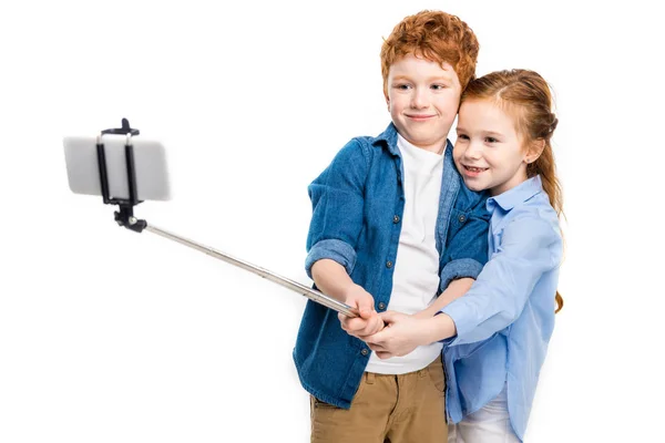 Beautiful happy redhead kids taking selfie with smartphone isolated on white — Stock Photo