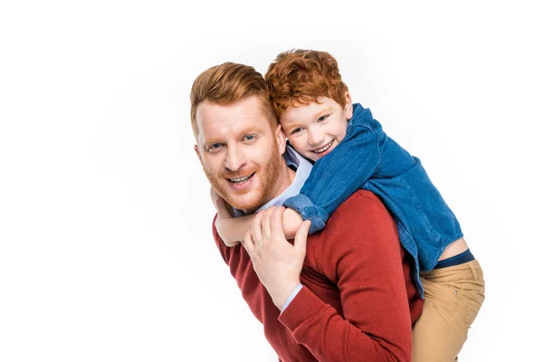 Alegre pelirroja padre e hijo abrazando y sonriendo a la cámara aislado en blanco - foto de stock