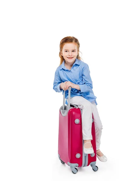 Entzückendes glückliches Kind sitzt auf Koffer isoliert auf weiß — Stockfoto