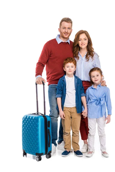 Feliz pelirroja familia con maleta de pie juntos y sonriendo a la cámara aislado en blanco - foto de stock