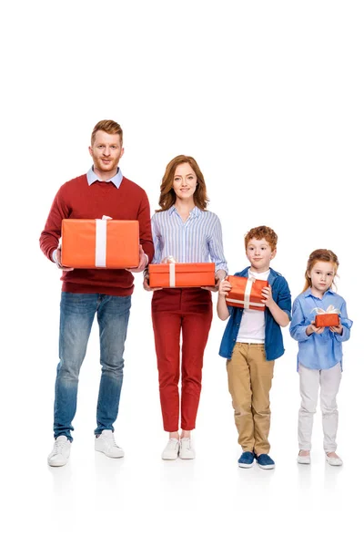 Щаслива родина з червоним волоссям тримає подарунки і посміхається на камеру ізольовано на білому — стокове фото
