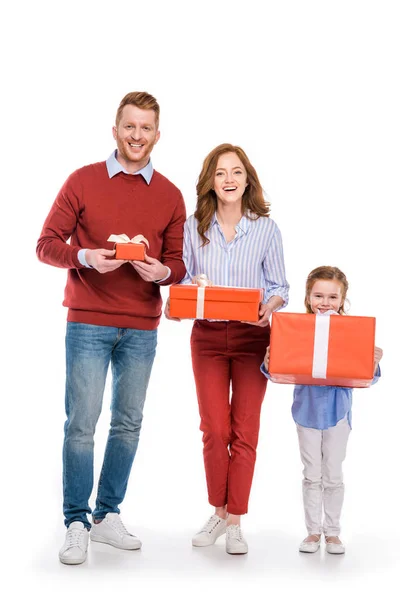 Щаслива сім'я з однією дитиною тримає подарунки і посміхається на камеру ізольовано на білому — стокове фото