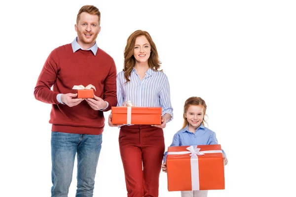 Щаслива руда сім'я тримає подарункові коробки і посміхається на камеру ізольовано на білому — стокове фото