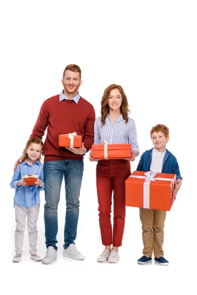 Glückliche rothaarige Familie hält Geschenke in der Hand und lächelt in die Kamera isoliert auf weiß — Stockfoto