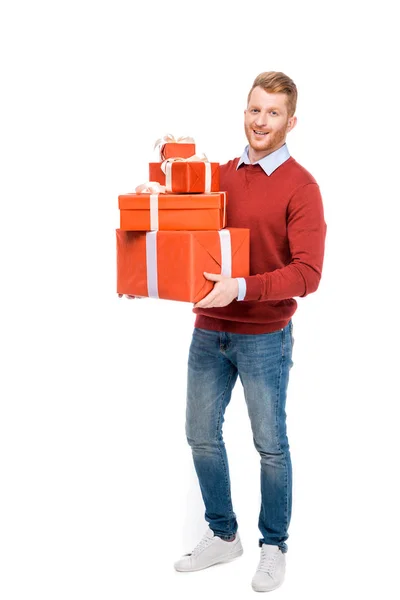 Pleine longueur vue de beau barbu rousse homme tenant des cadeaux et souriant à la caméra isolé sur blanc — Photo de stock