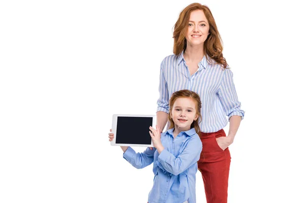 Feliz madre e hija con tableta digital sonriendo a la cámara aislada en blanco - foto de stock