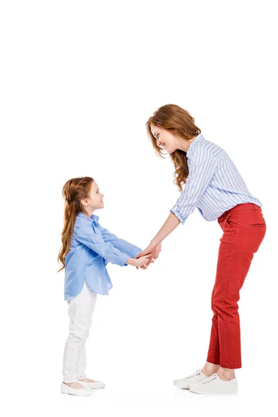 Seitenansicht von glücklichen rothaarigen Mutter und Tochter Händchen haltend und einander lächelnd isoliert auf weiß — Stockfoto