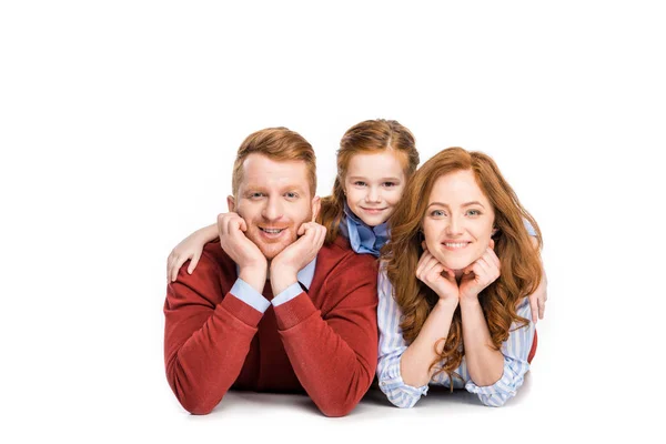 Glückliche Eltern mit entzückender kleiner Tochter, die zusammen liegt und isoliert auf Weiß in die Kamera lächelt — Stockfoto