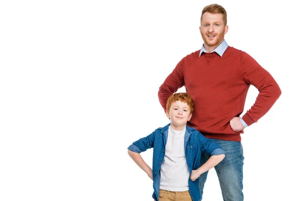 Felice padre e figlio in piedi con le mani in vita e sorridente alla fotocamera isolata su bianco — Foto stock