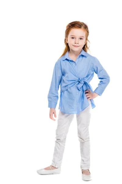 Vista de longitud completa de lindo niño pequeño de pie con la mano en la cintura y sonriendo a la cámara aislada en blanco - foto de stock