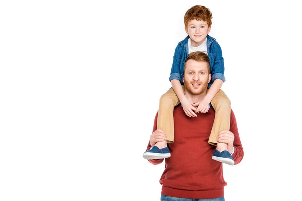 Lindo niño sentado en el cuello de padre feliz y sonriendo a la cámara aislado en blanco - foto de stock