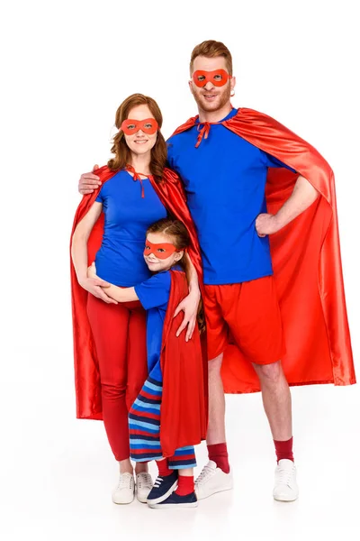 Super família em máscaras e capas de pé juntos e sorrindo para a câmera isolada em branco — Fotografia de Stock