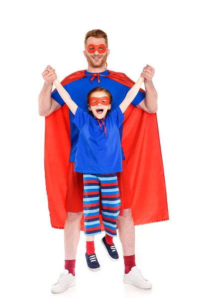 Heureux père et fille en costumes de super-héros s'amuser ensemble et sourire à la caméra isolé sur blanc — Photo de stock