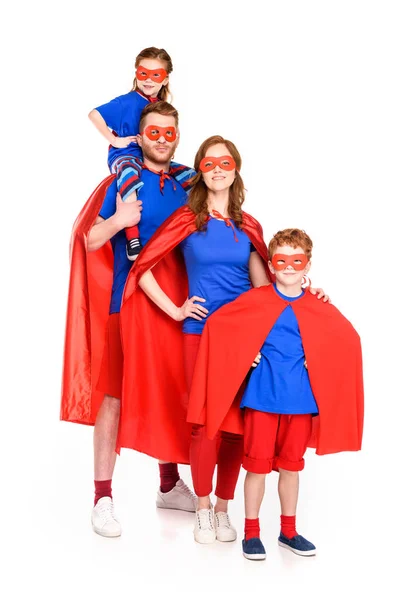 Familia de superhéroes con máscaras y capas sonriendo a la cámara aislada en blanco - foto de stock