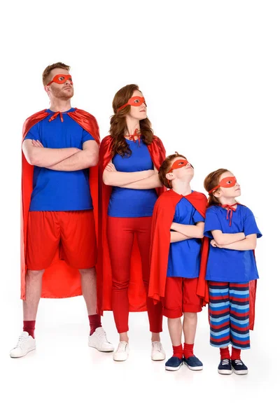 Family of superheroes in costumes standing with crossed arms and looking away isolated on white — Stock Photo