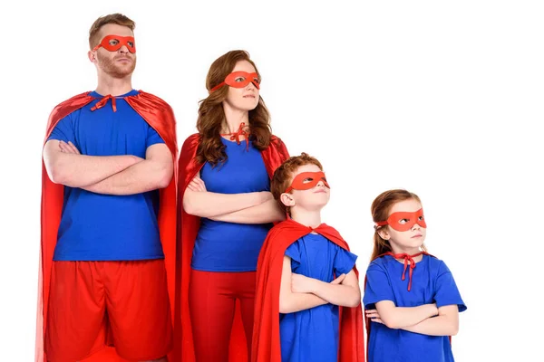 Confiante família de super-heróis em trajes de pé com braços cruzados e olhando para longe isolado no branco — Fotografia de Stock