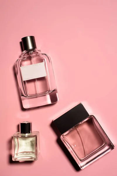 Top view of bottles of various of perfumes on pink surface — Stock Photo